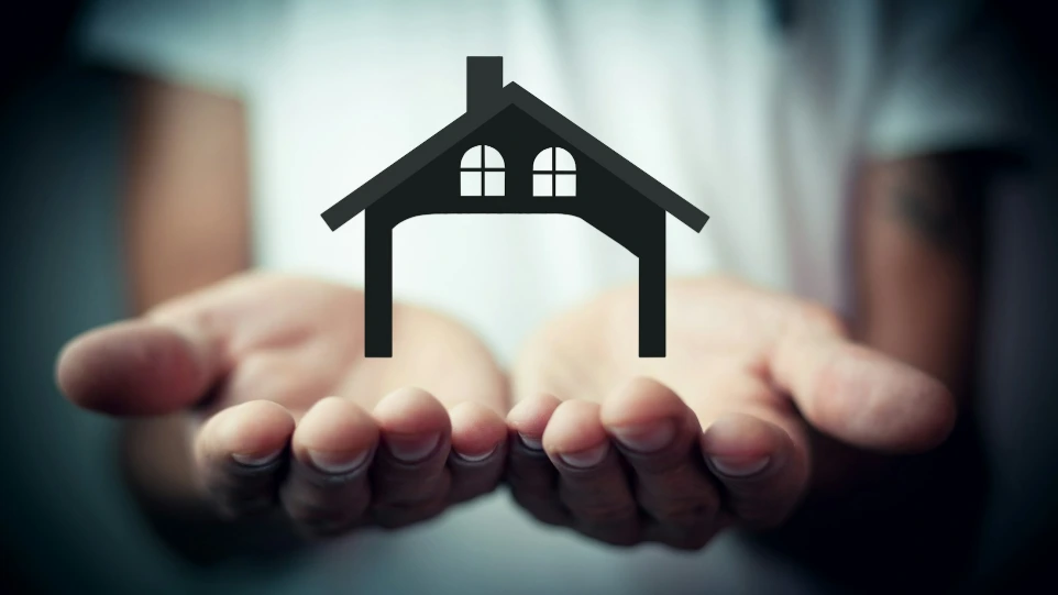 Hands holding a silhouette of a house